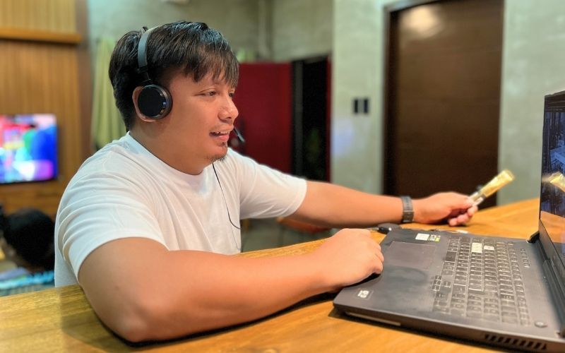 Male virtual assistant from The Side Hustle Squad wearing a headset while working on a laptop during an online client meeting.